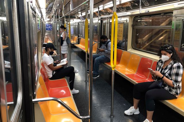 People wearing masks on subway car